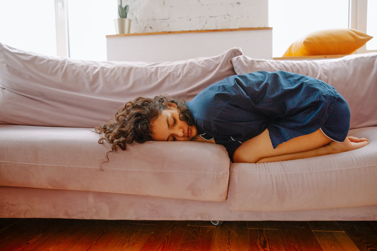 Persona descansando en un sofá que representa la apatía y la falta de energía asociadas a la depresión en verano